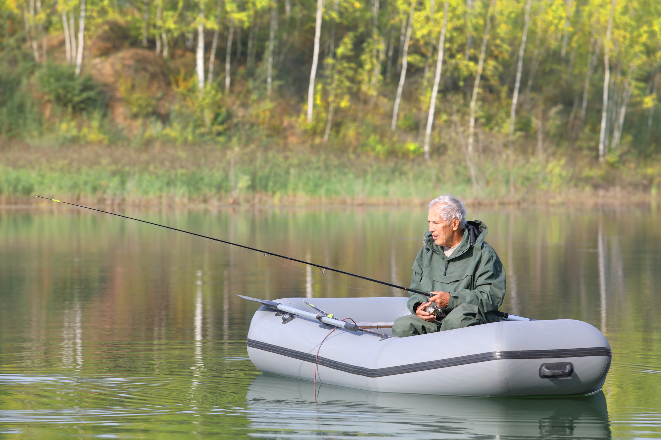 Senior man fishing in boat