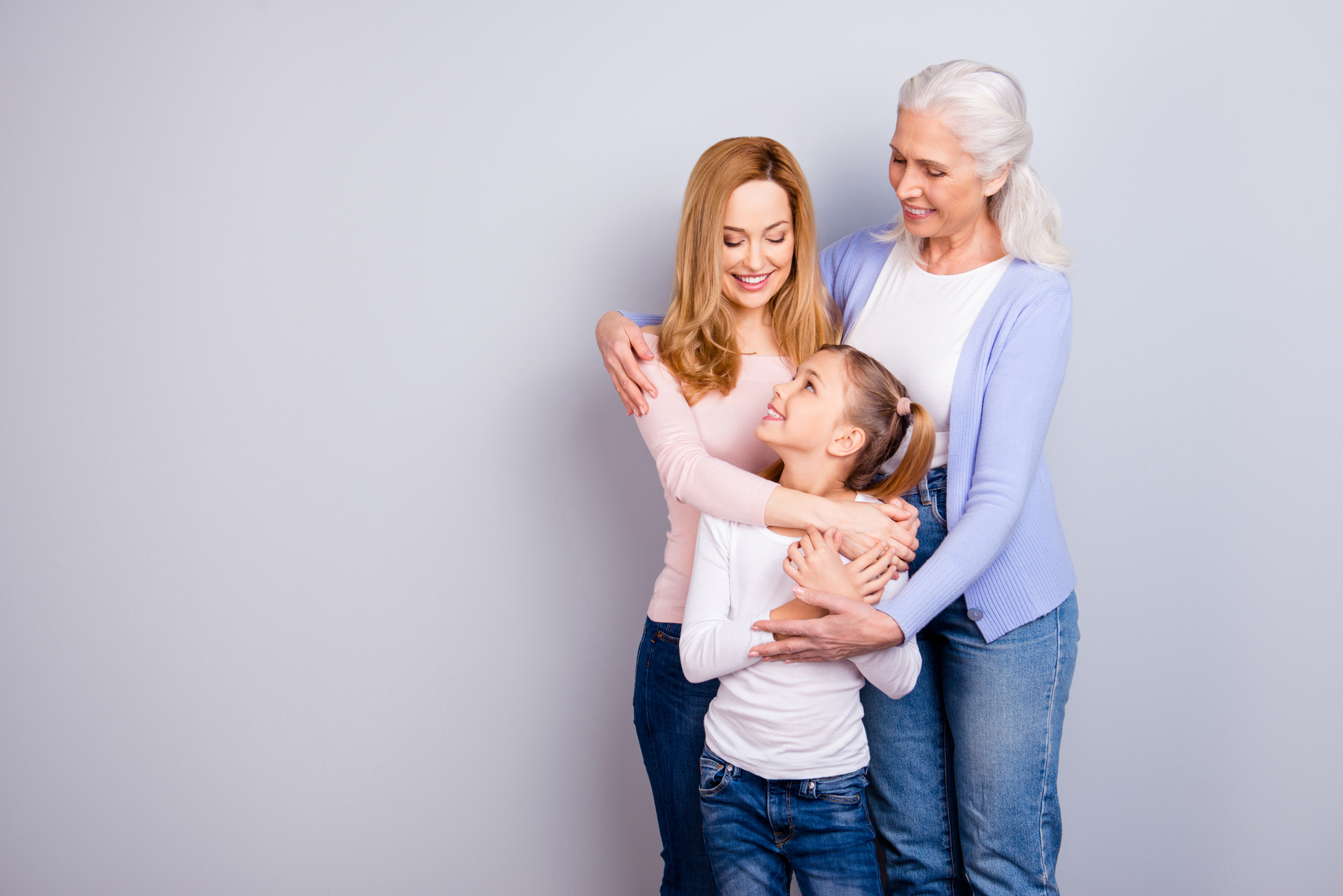 Young girl, woman, and older woman embracing