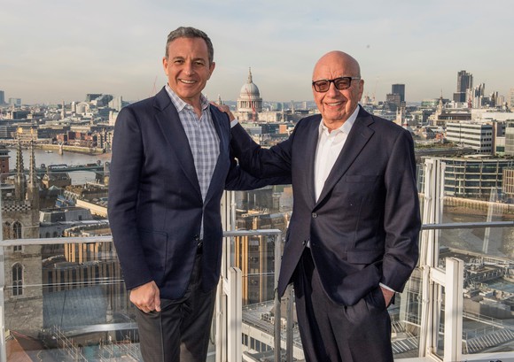 Disney CEO Bob Iger and Fox CEO Rupert Murdoch on a balcony, with a city in the background