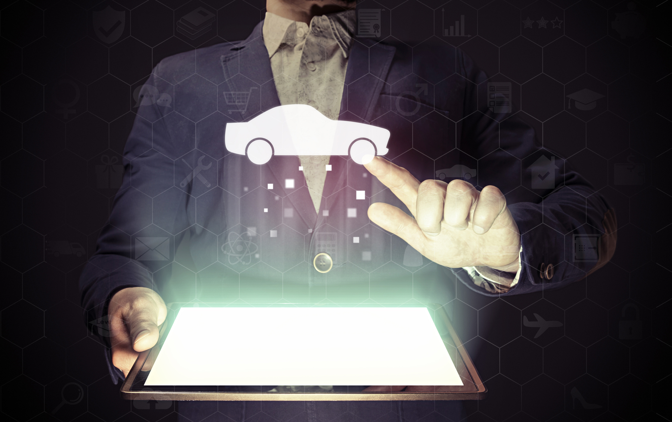 Man holding a lit-up tablet screen and pointing his left finger at a graphic of a vehicle hovering above it.