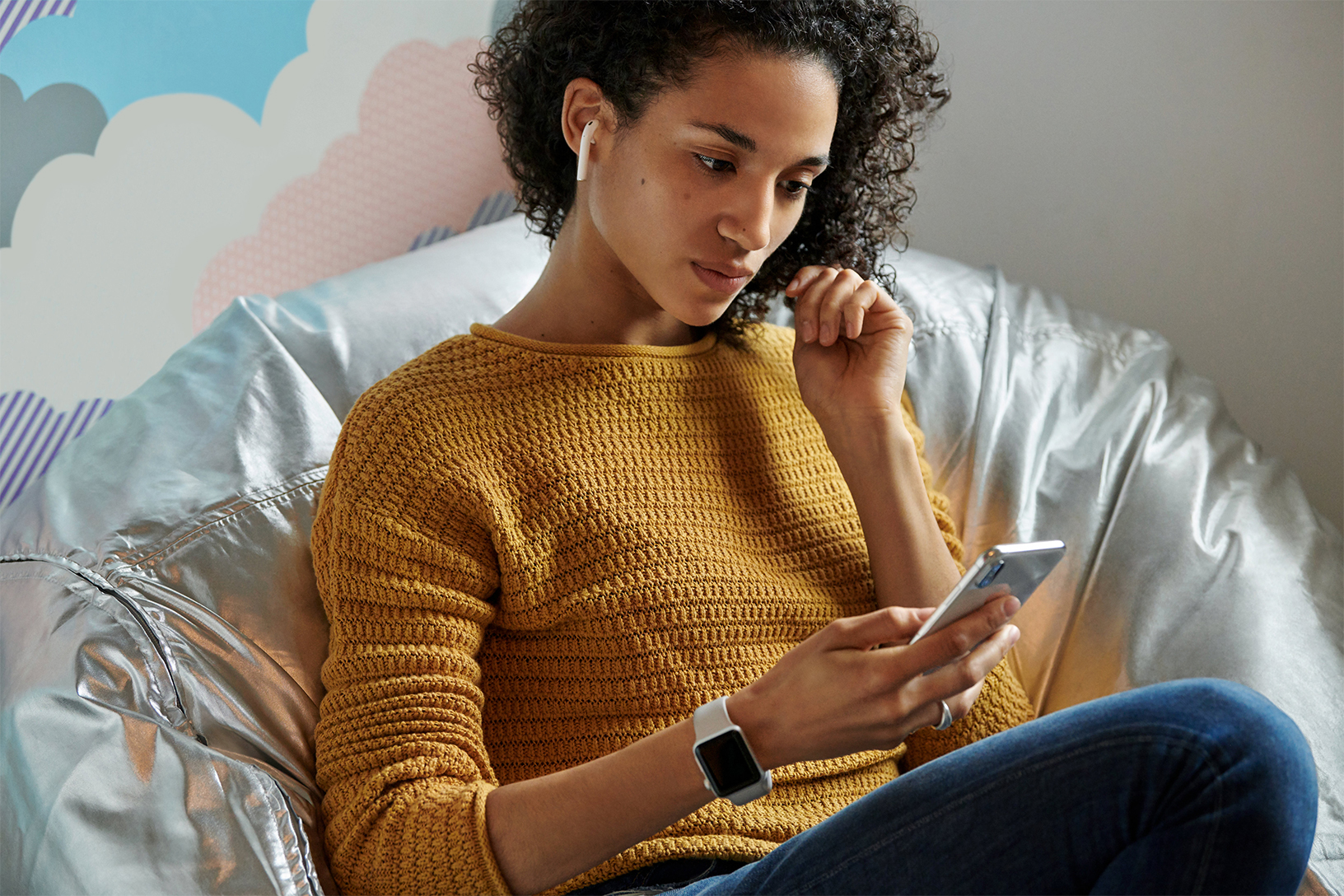 Woman using AirPods, Apple Watch, and iPhone