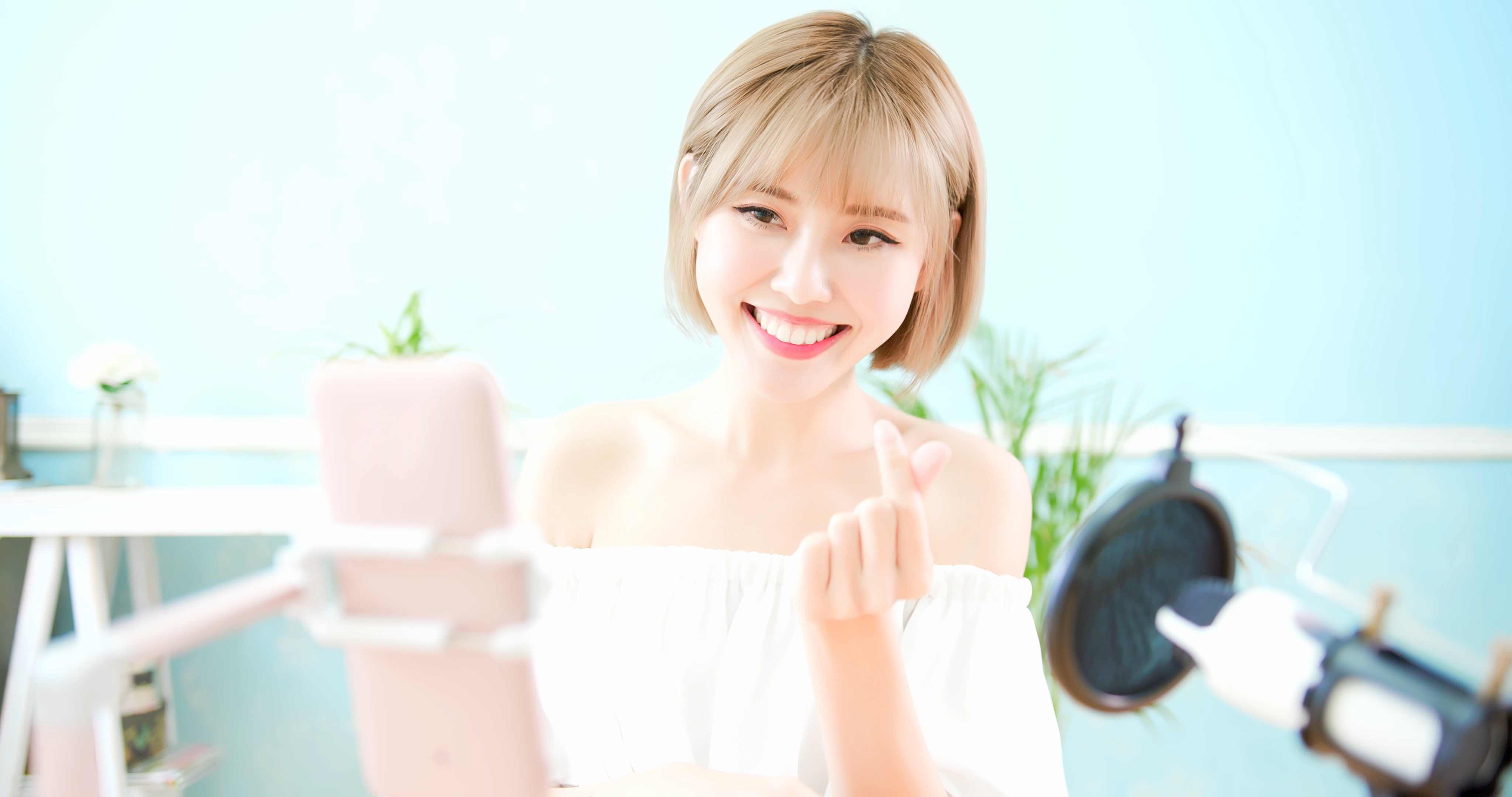 A young woman broadcasts a live video on a smartphone.