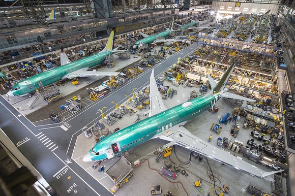 Three aircraft in an exhibition hangar with extensive office space.