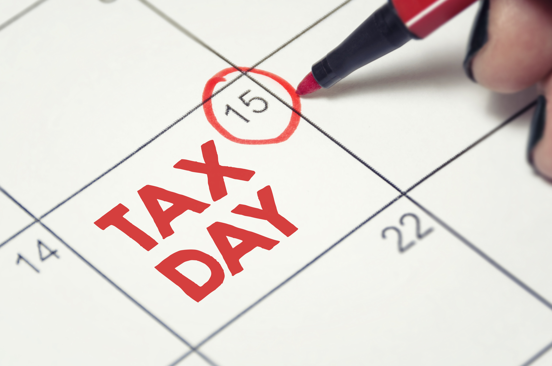 April 15 date circled in red on calendar, with the words TAX DAY written in red letters on that calendar square.