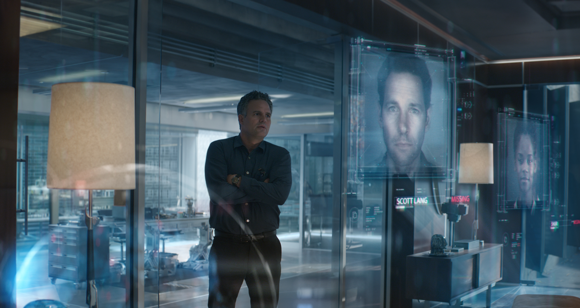 Actor Mark Ruffalo looking at digital projections of other Avengers characters.