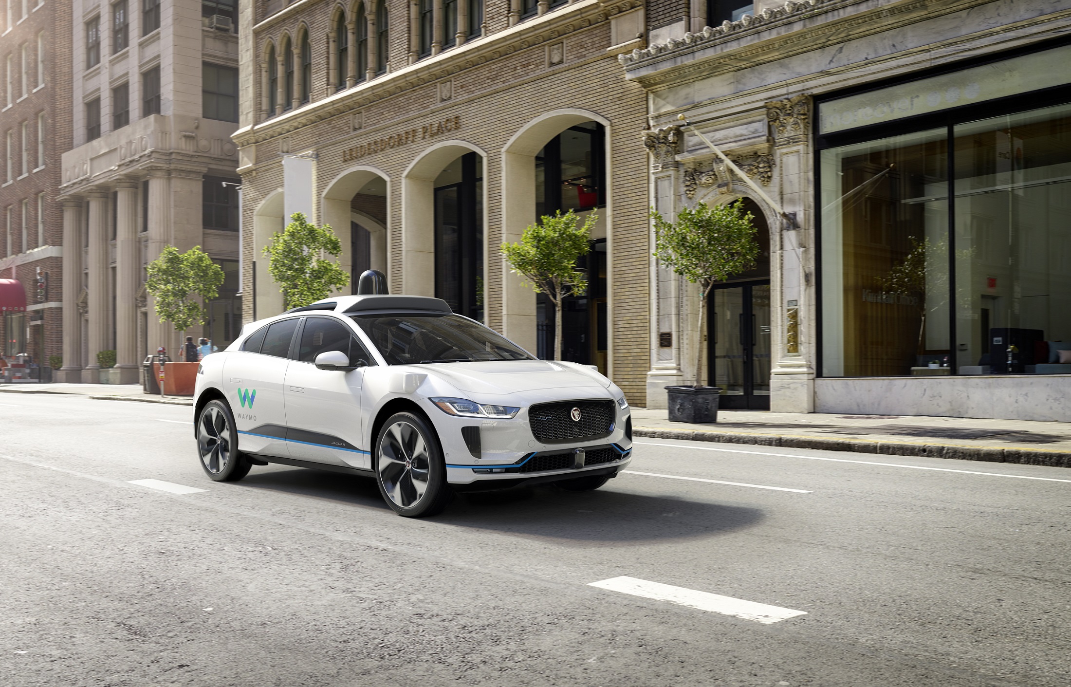 A white self-driving vehicle made by Alphabet subsidiary Waymo in the middle of an empty city street.