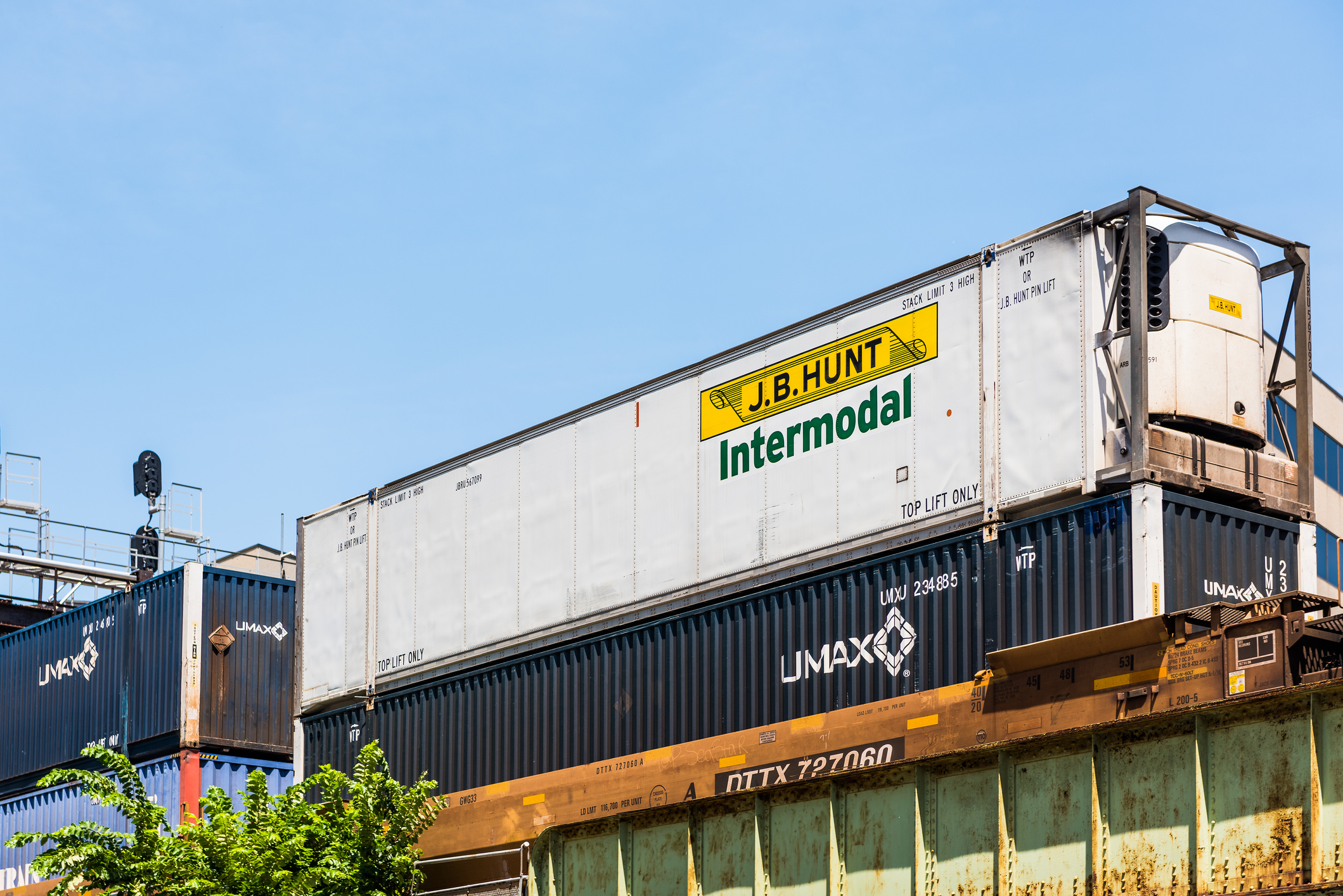 A J.B. Hunt intermodal shipping crate on a rail flatbed.