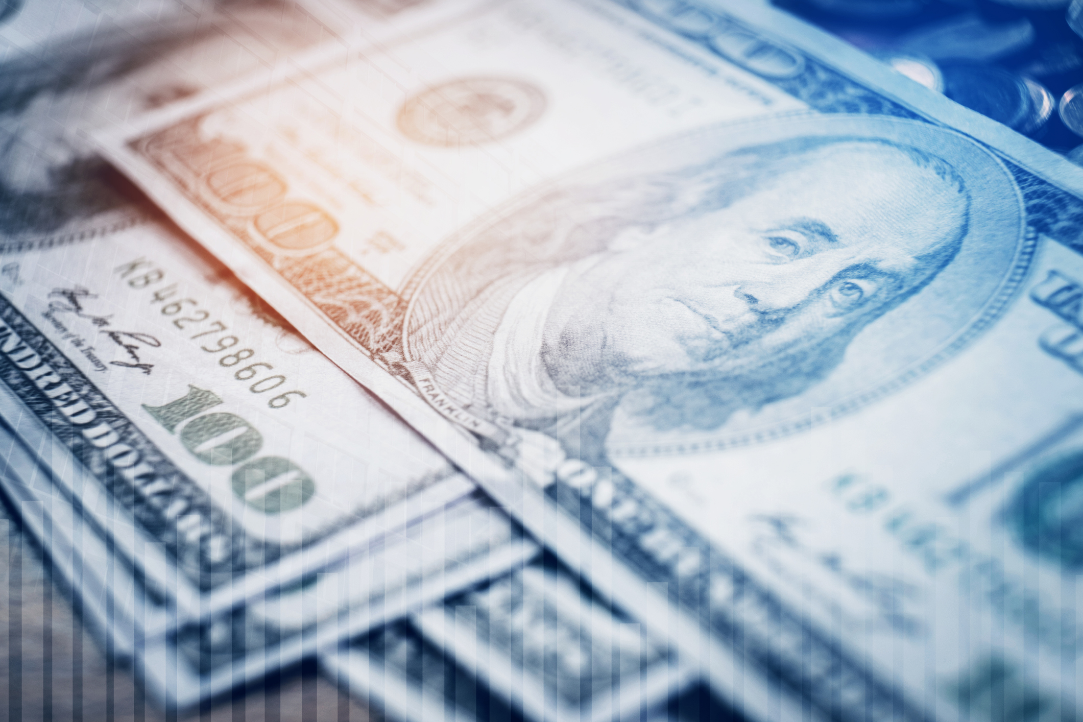 Several $100 bills on top of each other