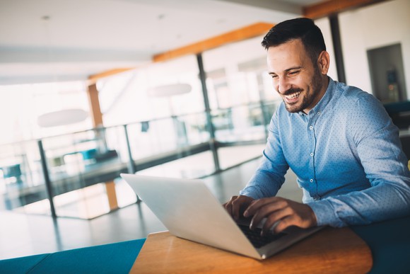Happy man using laptop.