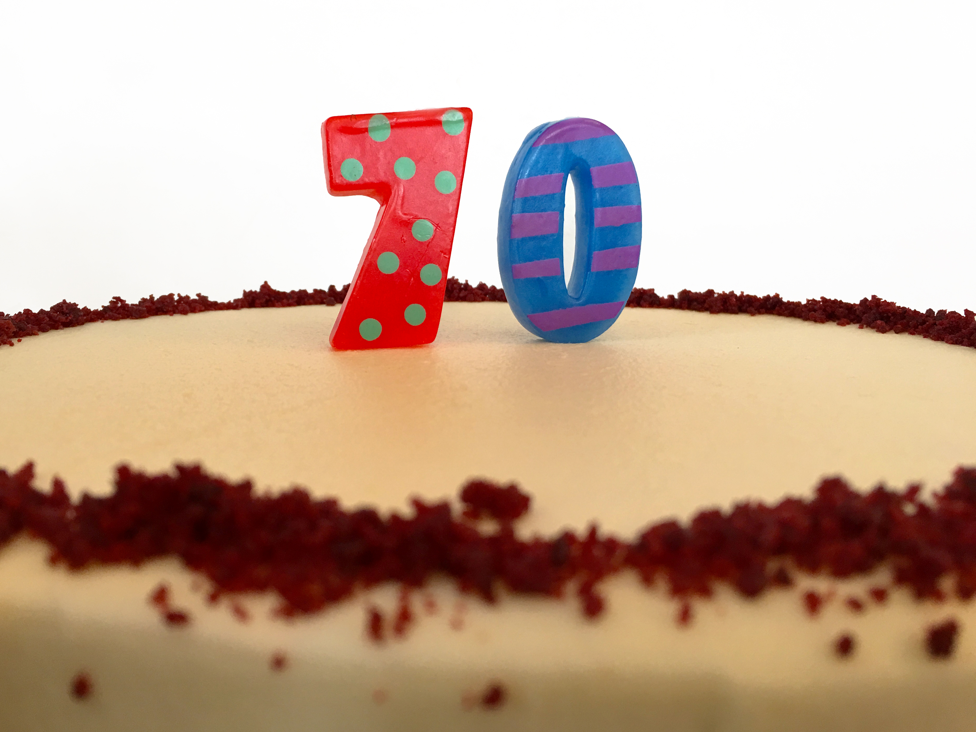 Cake with candles spelling out 70 on top.