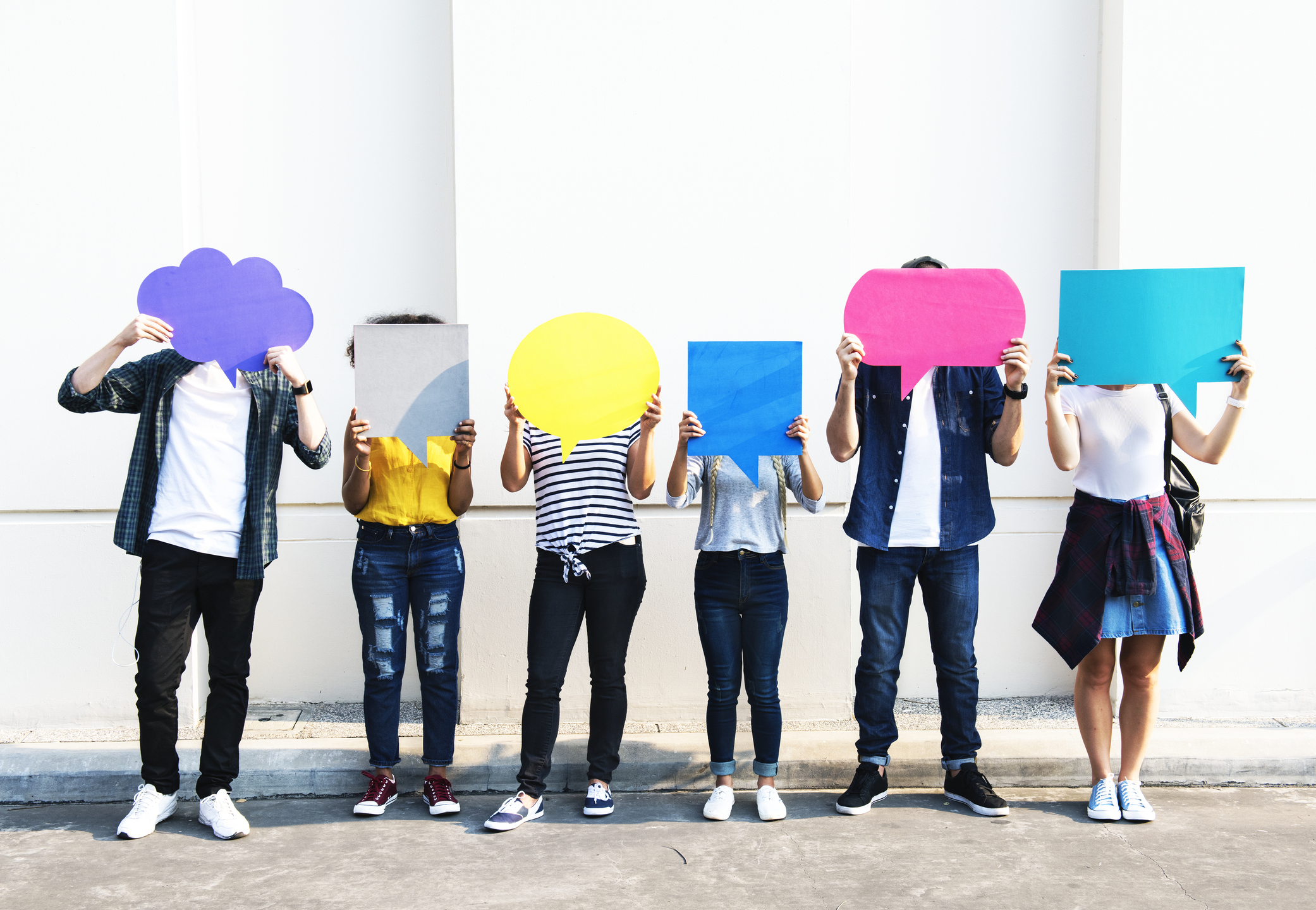 Teens holding cardboard speech bubbles.