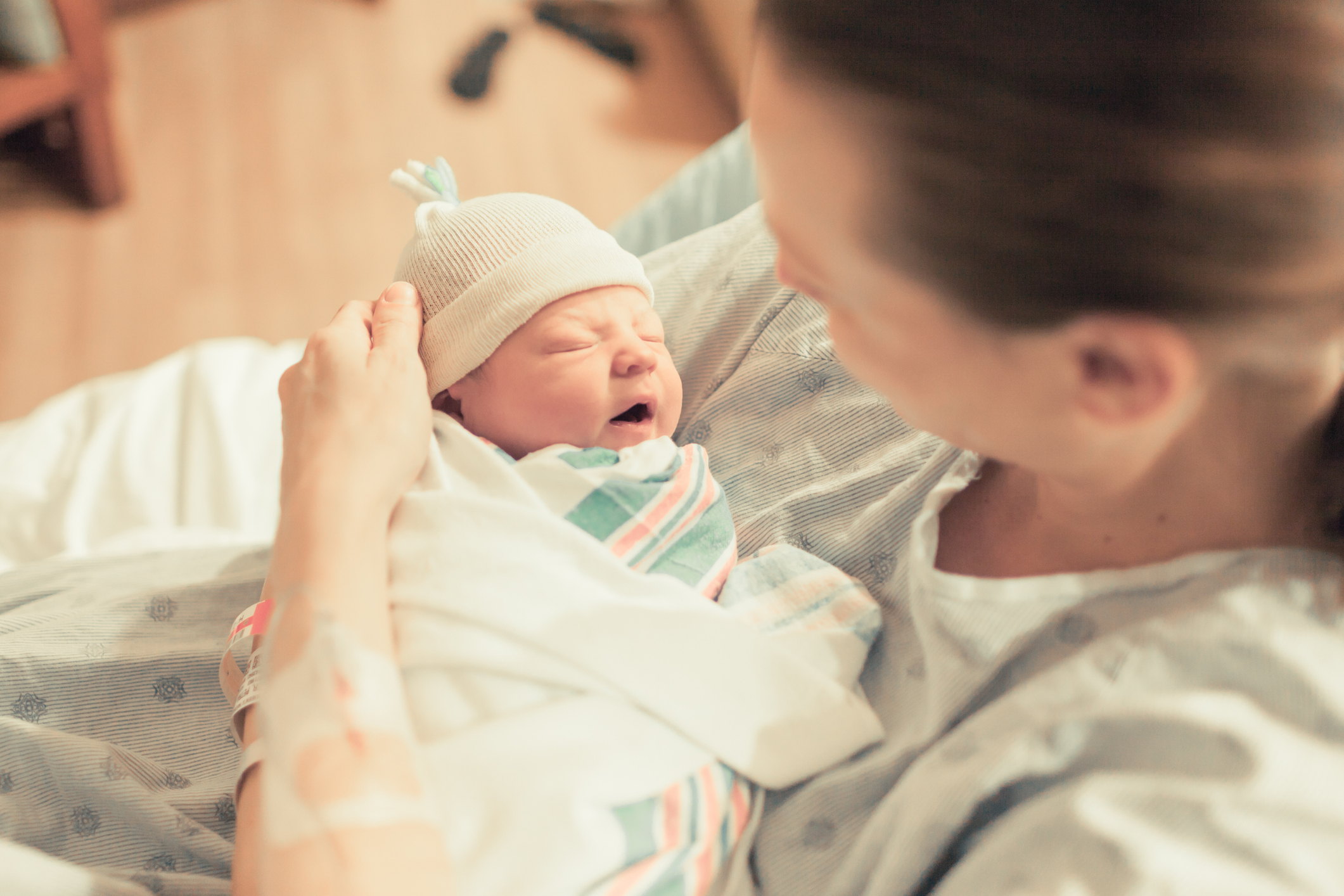 A woman holds a newborn baby.