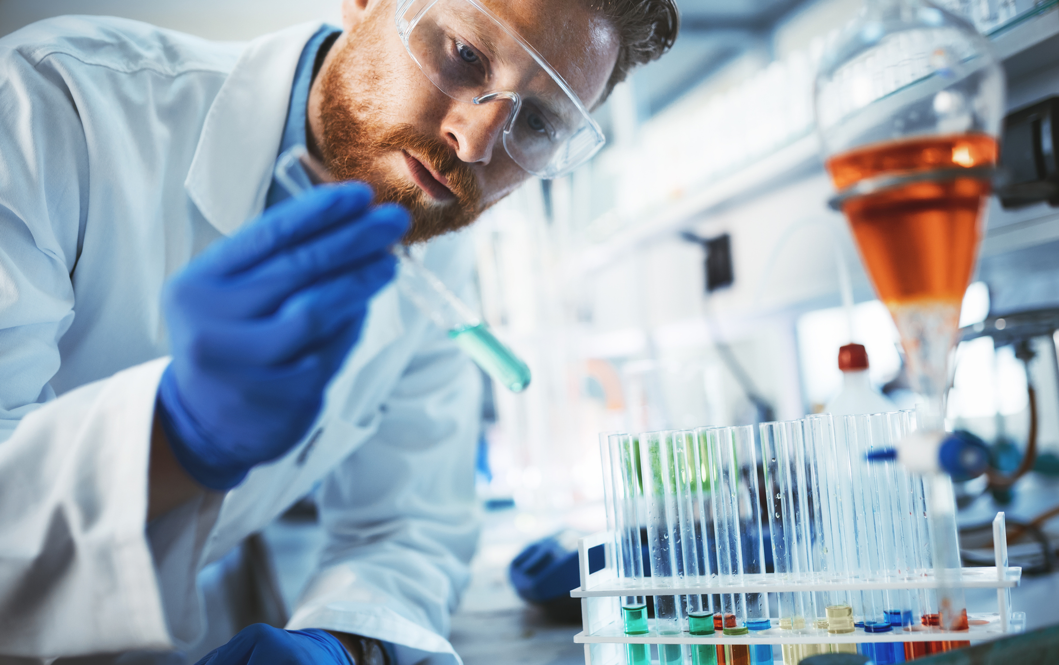 A male scientist in a lab holding a test tube