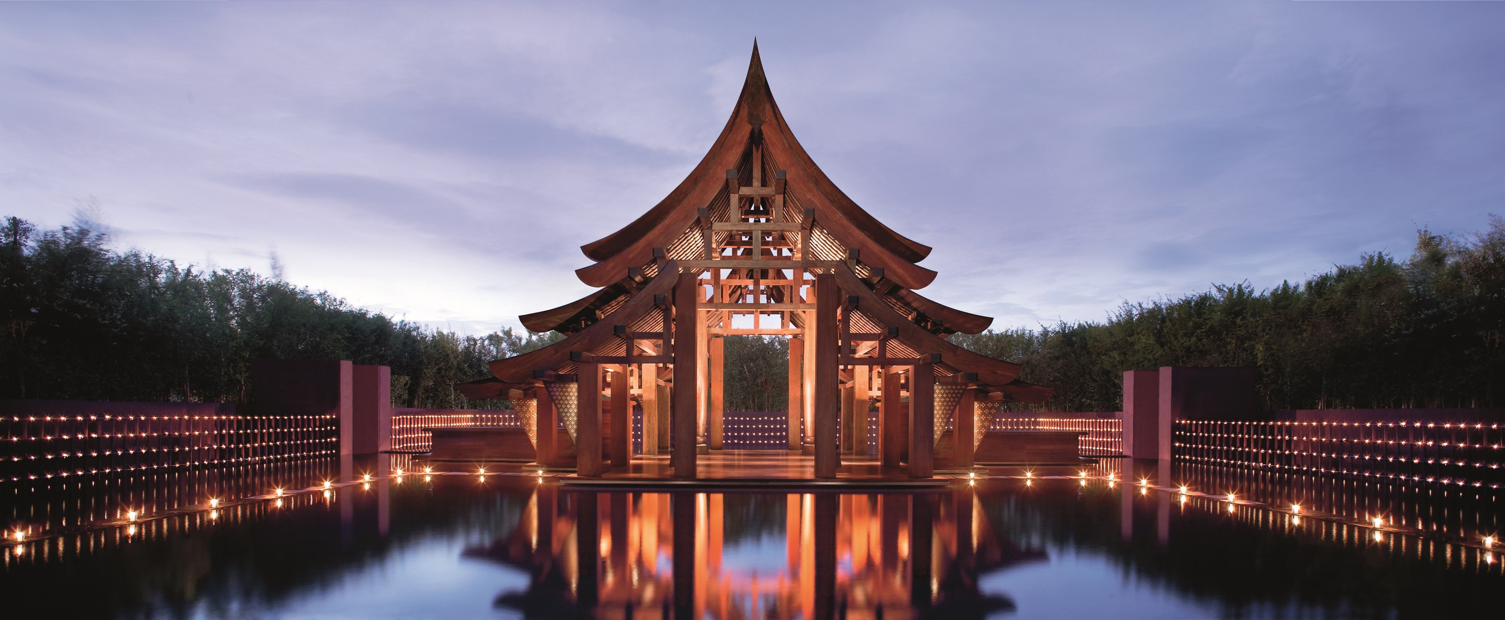 A view of a building with its reflection in a pool in front.