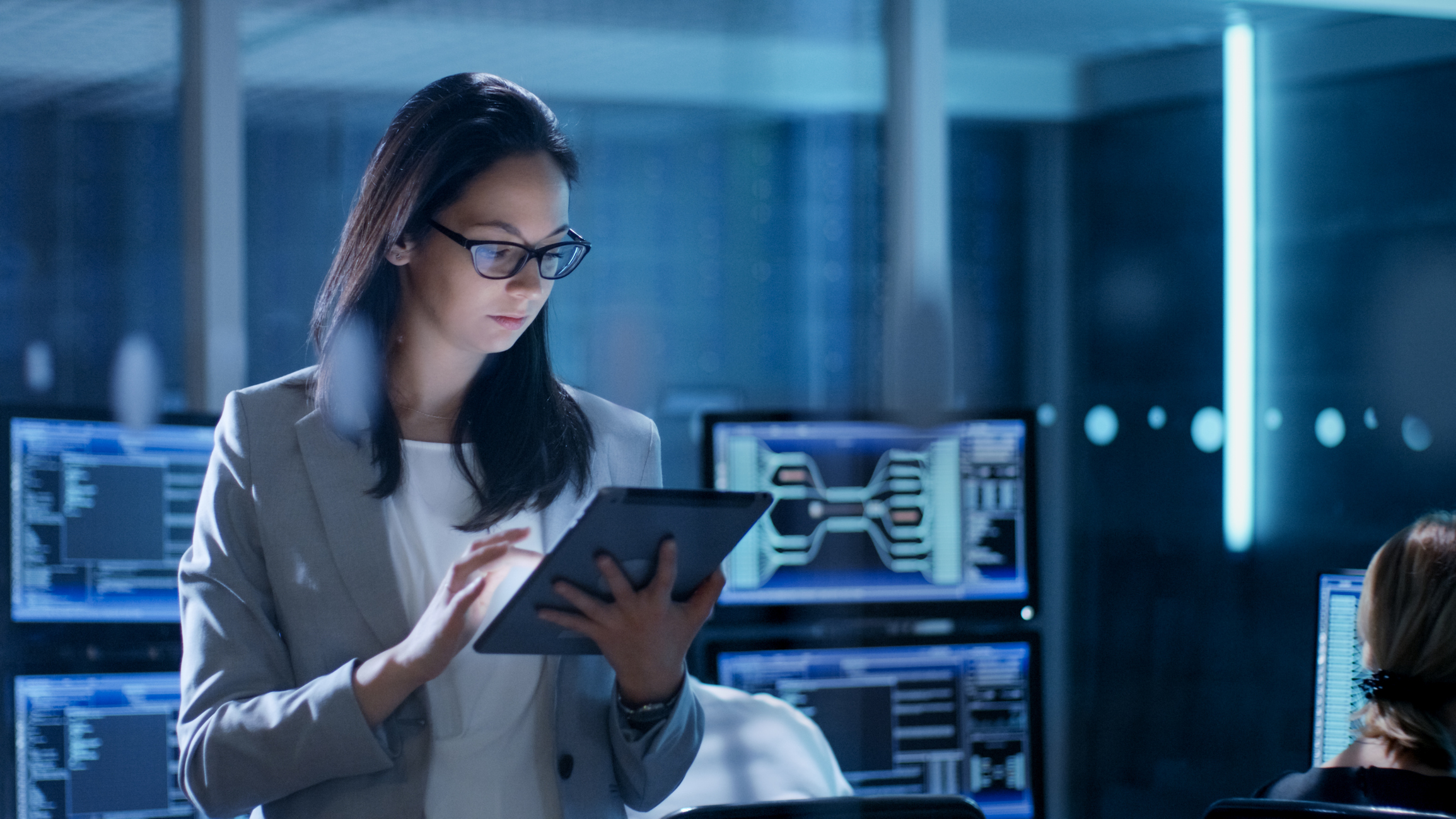 Woman in server room with tablet in her hand