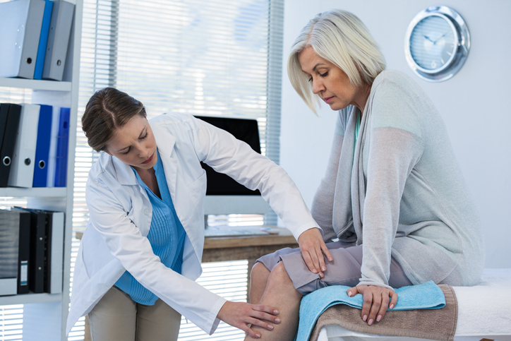 A doctor examining a patient's knee.