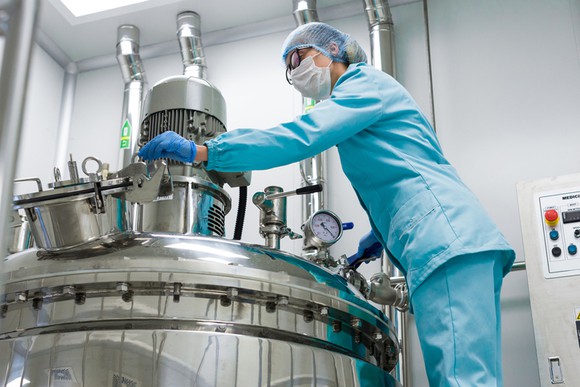 A technician checking a bioreactor.
