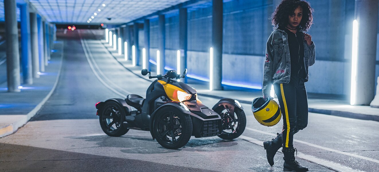 Woman standing next to three-wheeled motorcycle