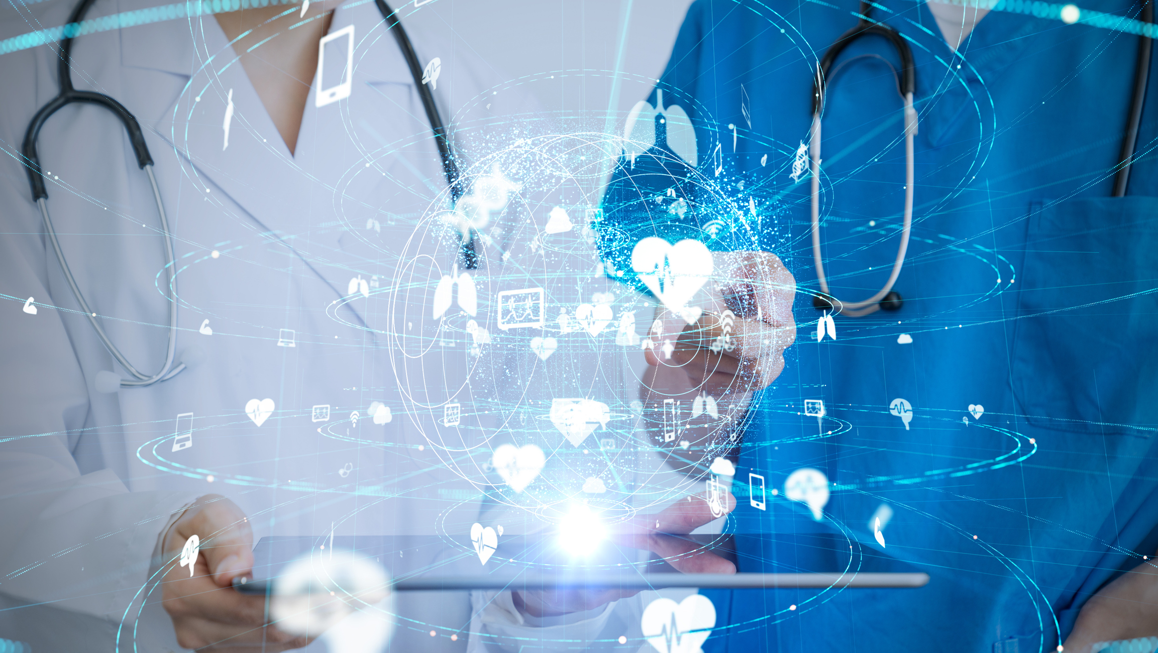 Two medical professionals holding a tablet with medical technology icons coming out of it.