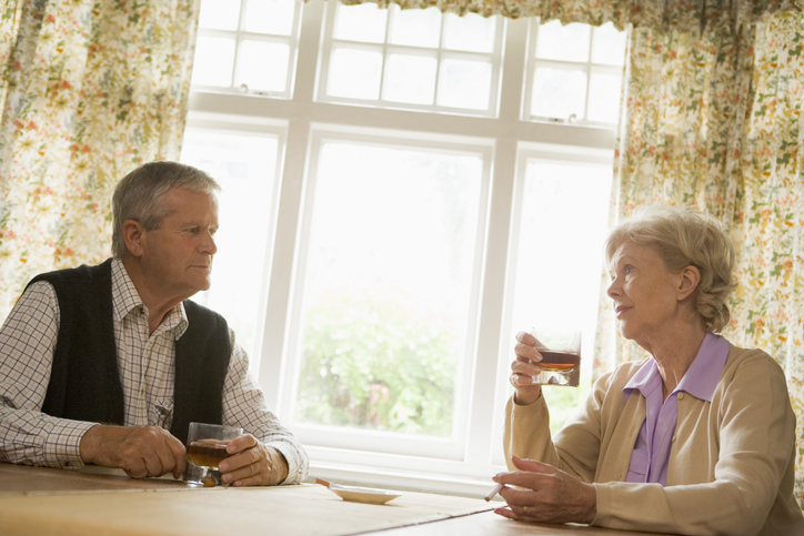 Senior couple at table with serious expressions