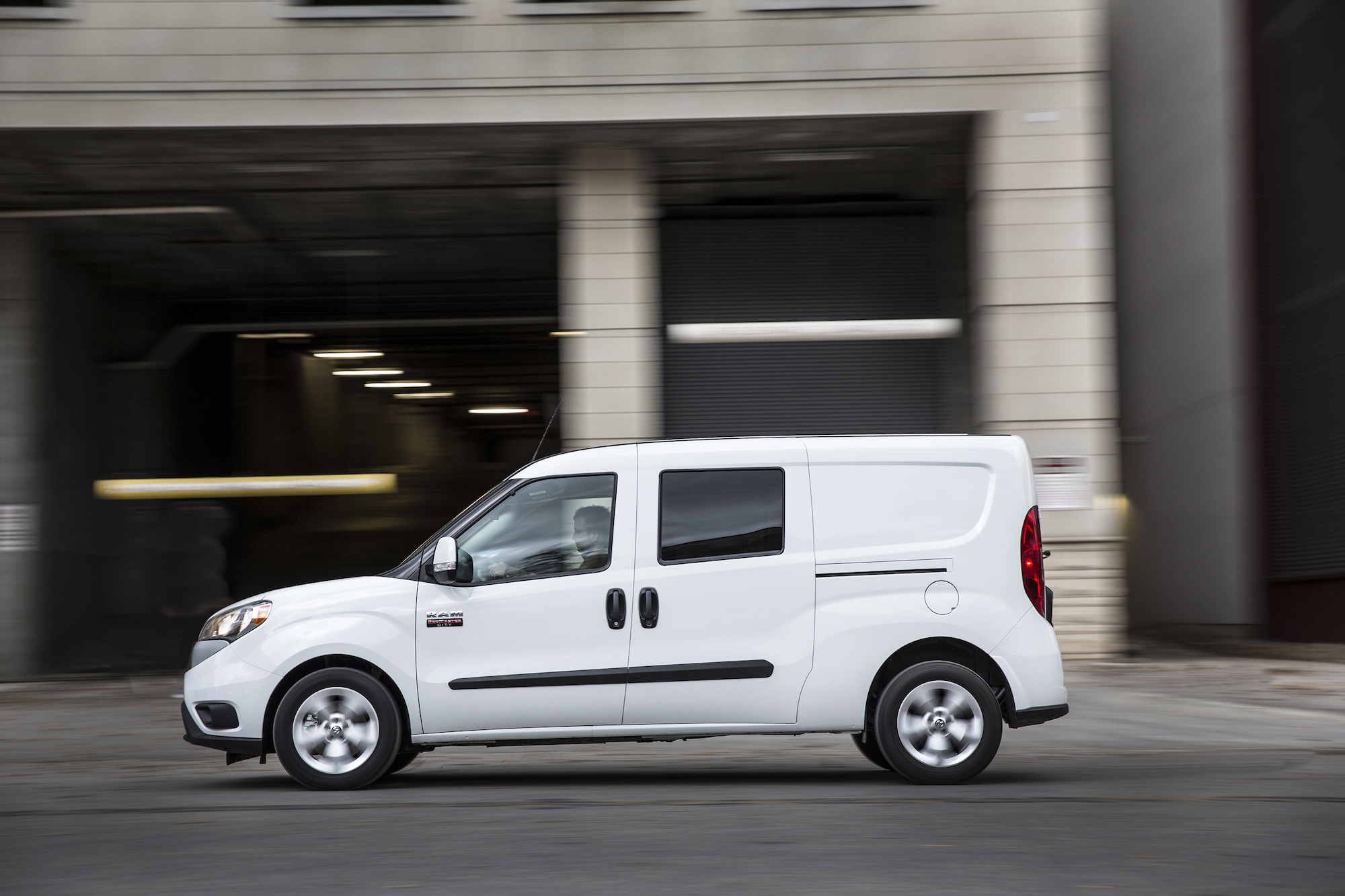 White van driving on the road.