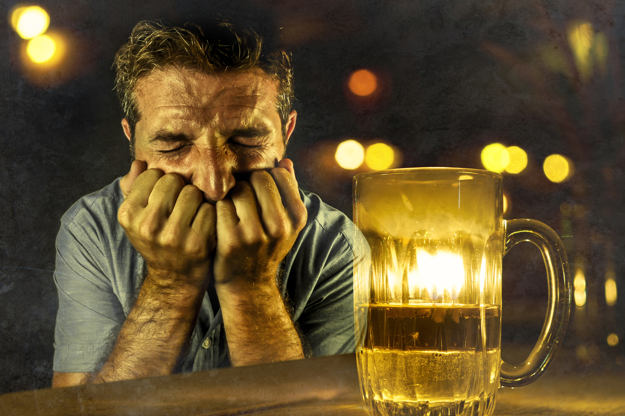 Cringing man next to mostly empty glass of beer