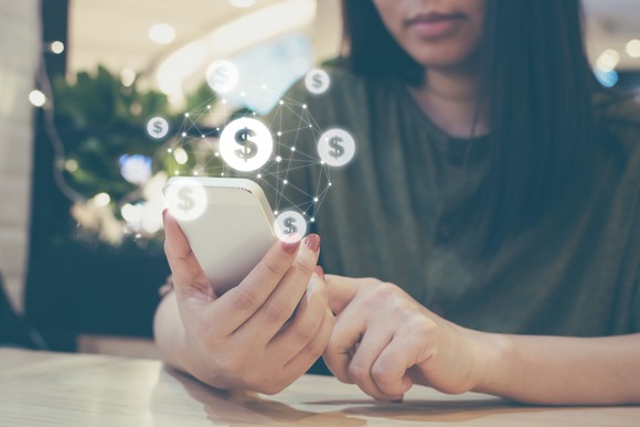 A young woman makes a payment on her smartphone.