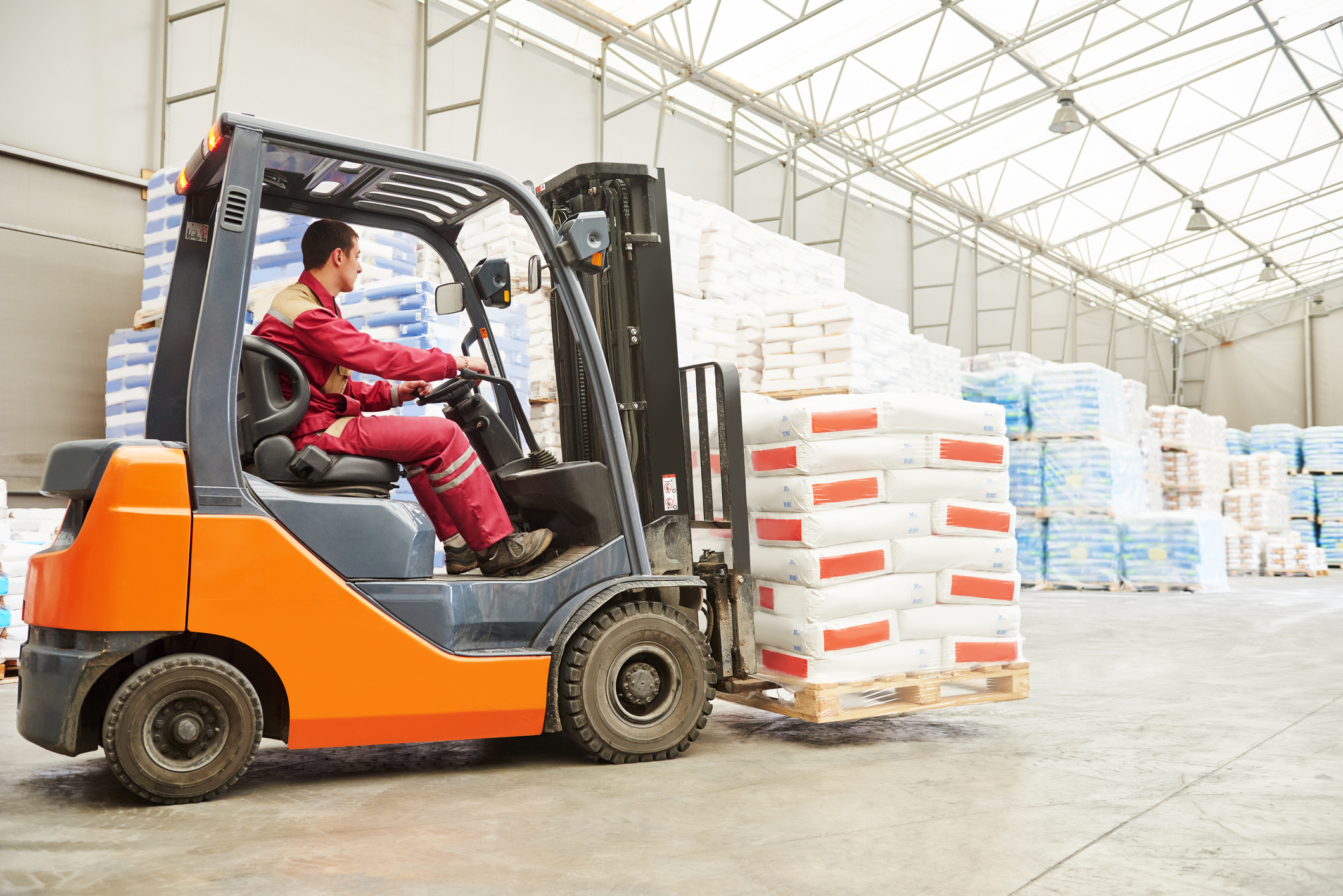 A forklift transports a pallet through a warehouse