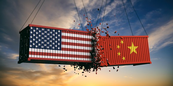 Two shipping containers -- one with a US flag and one with a Chinese flag -- crash into one another.
