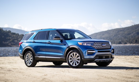 A blue 2020 Ford Explorer, a midsize three-row crossover SUV, parked on a lakefront