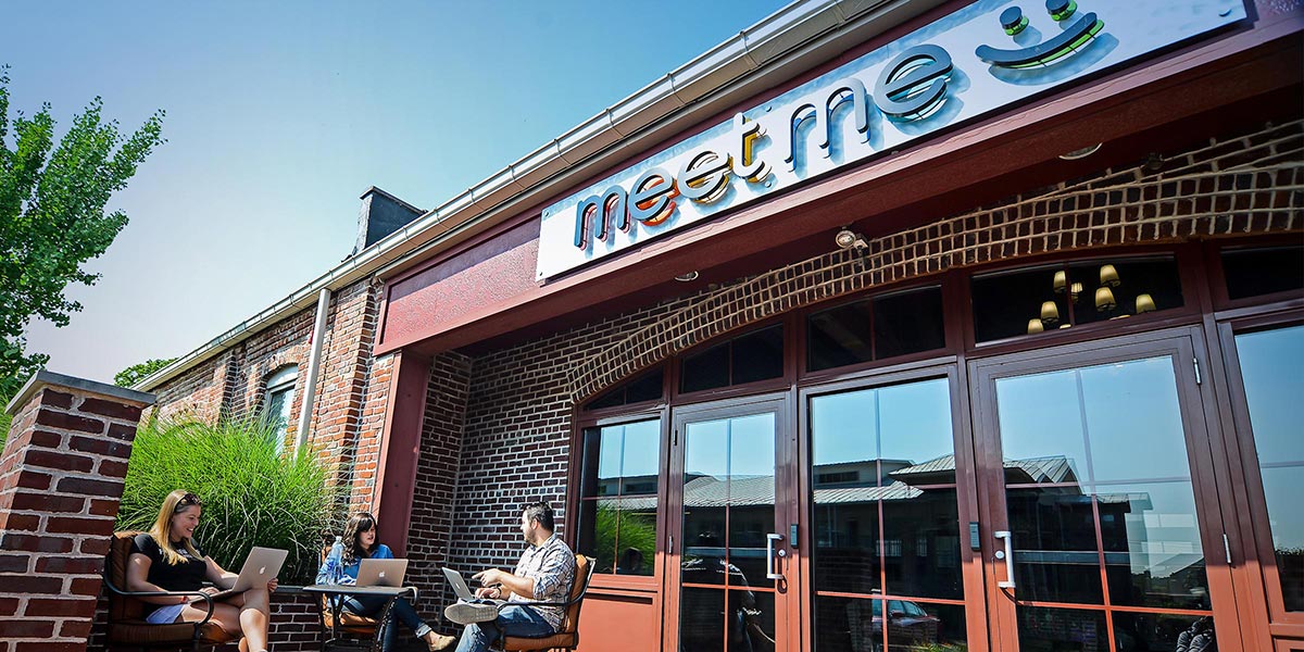 Three employees sitting outside of MeetMe's corporate office.
