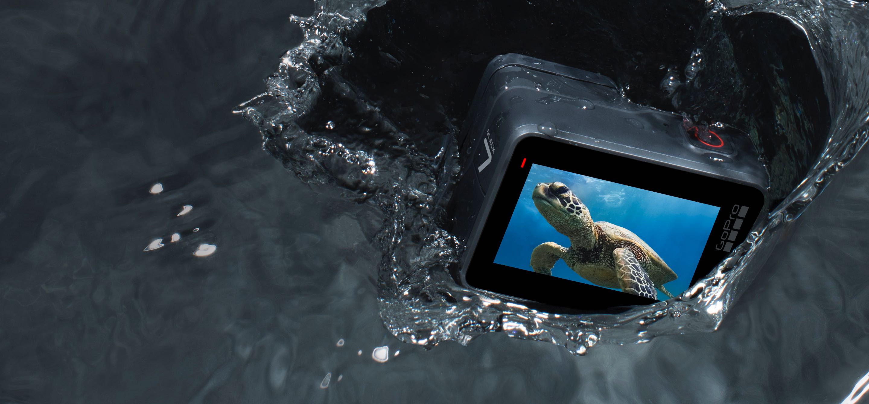 GoPro HERO 7 Black camera falling into dark gray water.