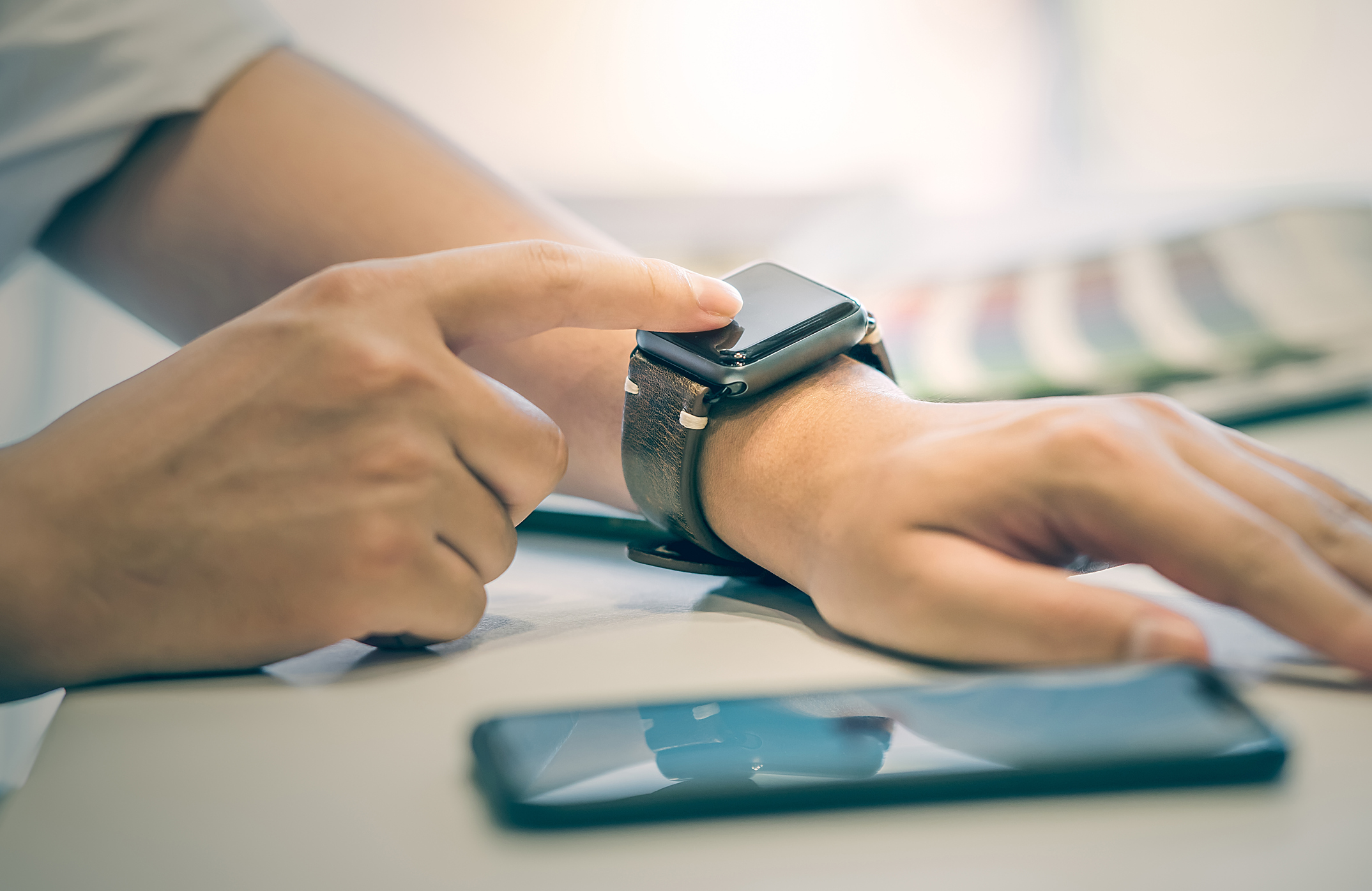 A person touches a smartwatch.