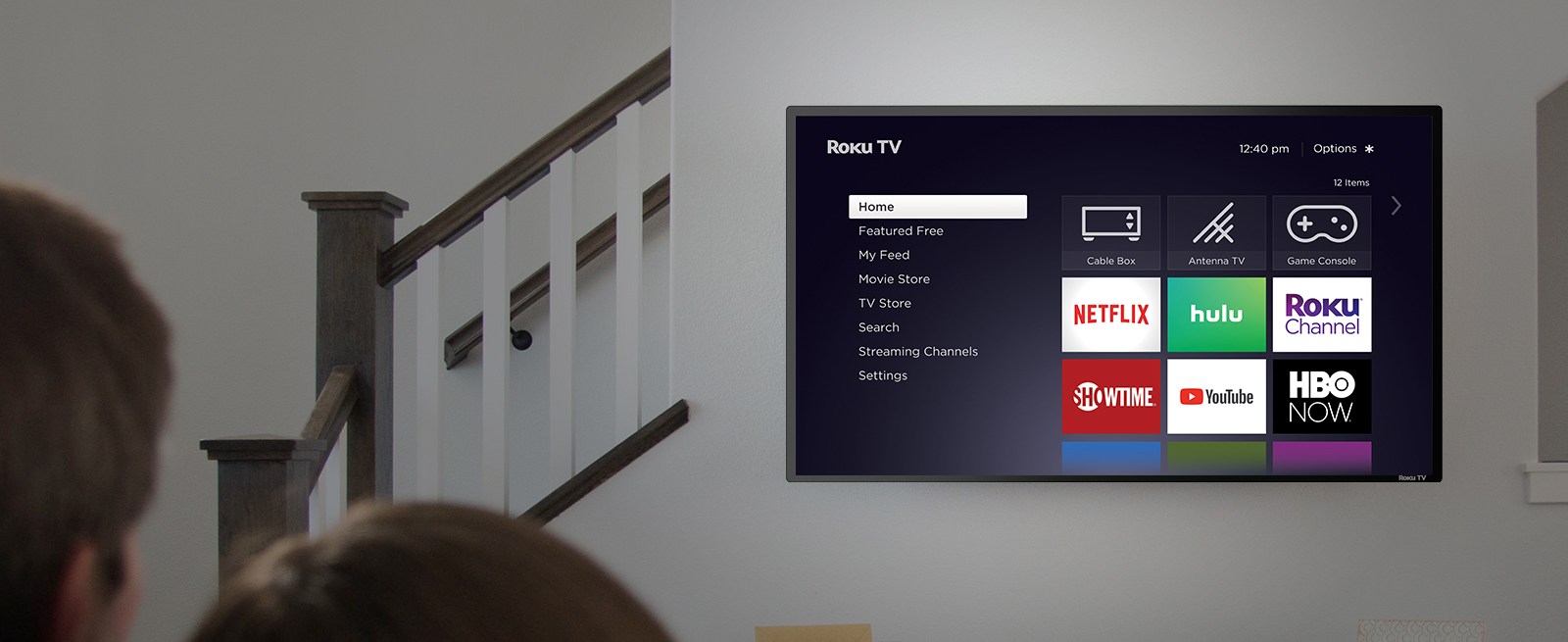 A Roku TV mounted on the living room wall, showing various viewing options.
