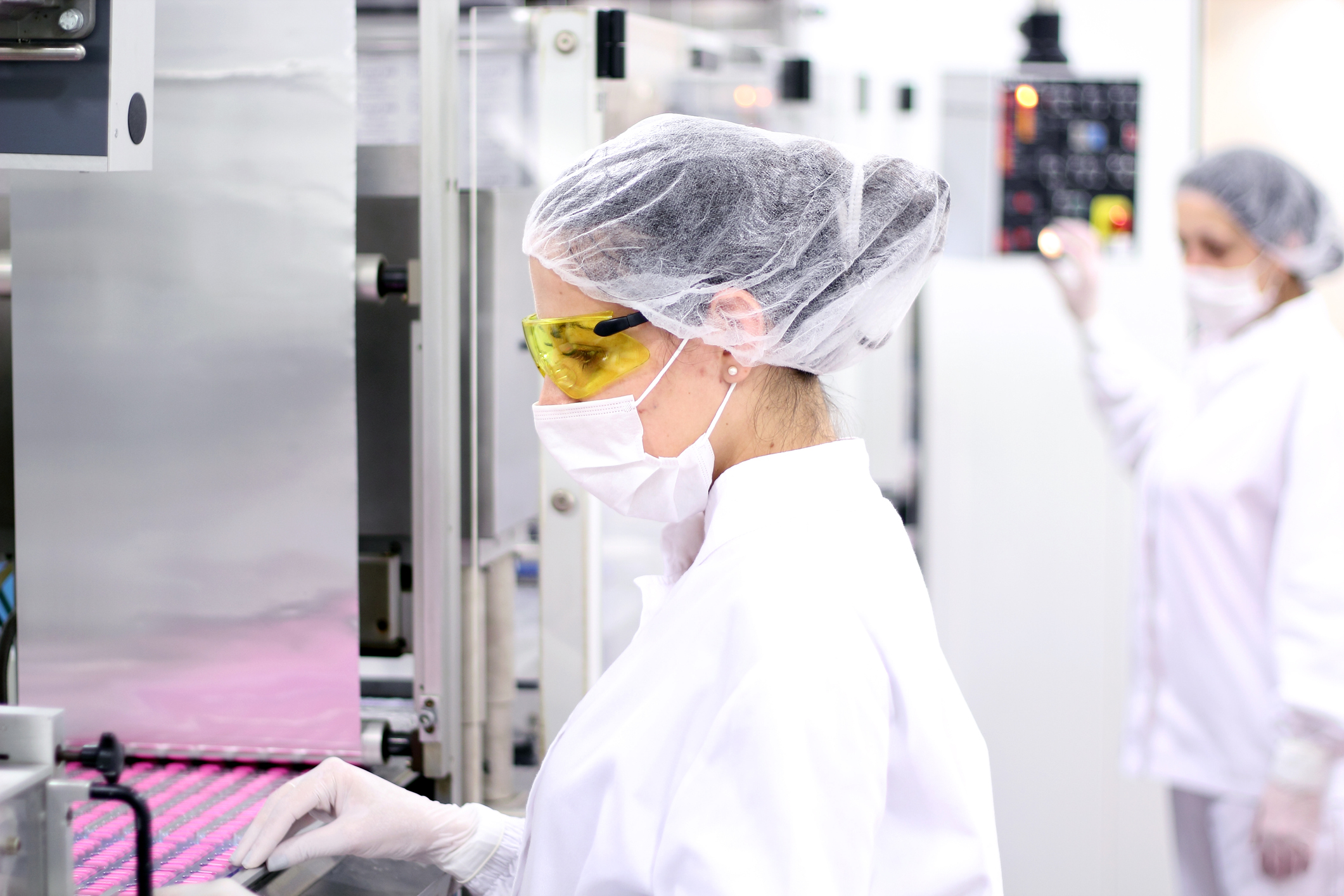 Two female technicians working in drug factory