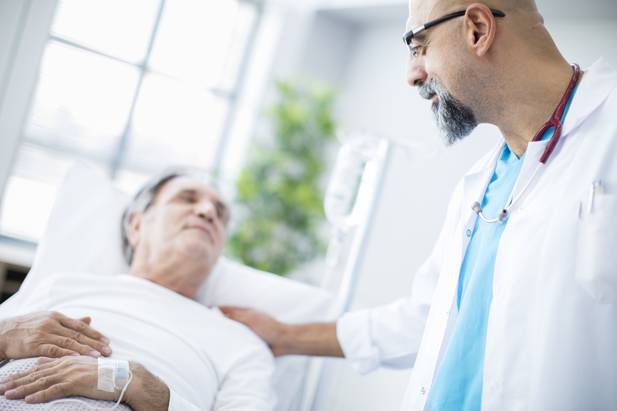 Doctor putting his hand on and elderly patient
