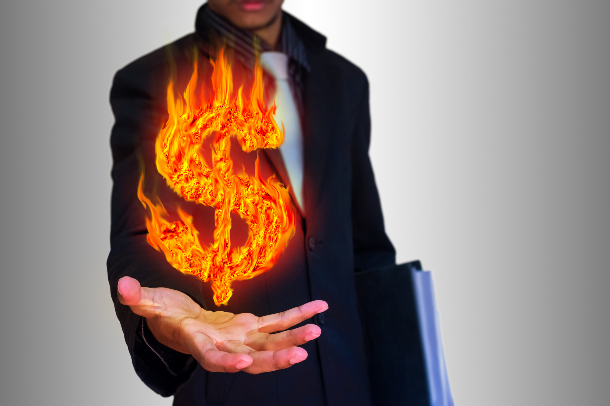 A flaming dollar sign hovers above a man's outstretched hand.