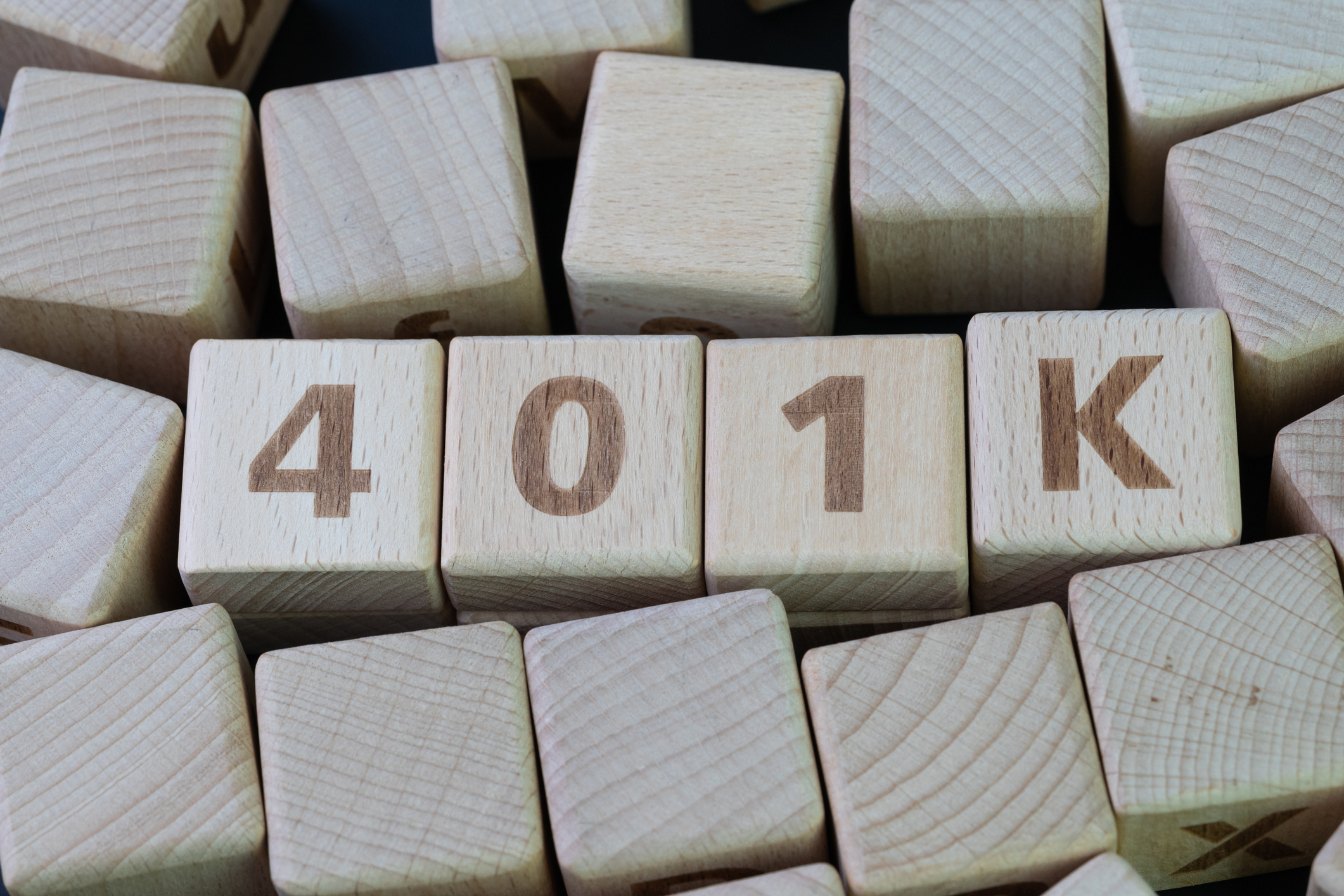 Bunch of wooden blocks with 401K written across those in the middle of the pile