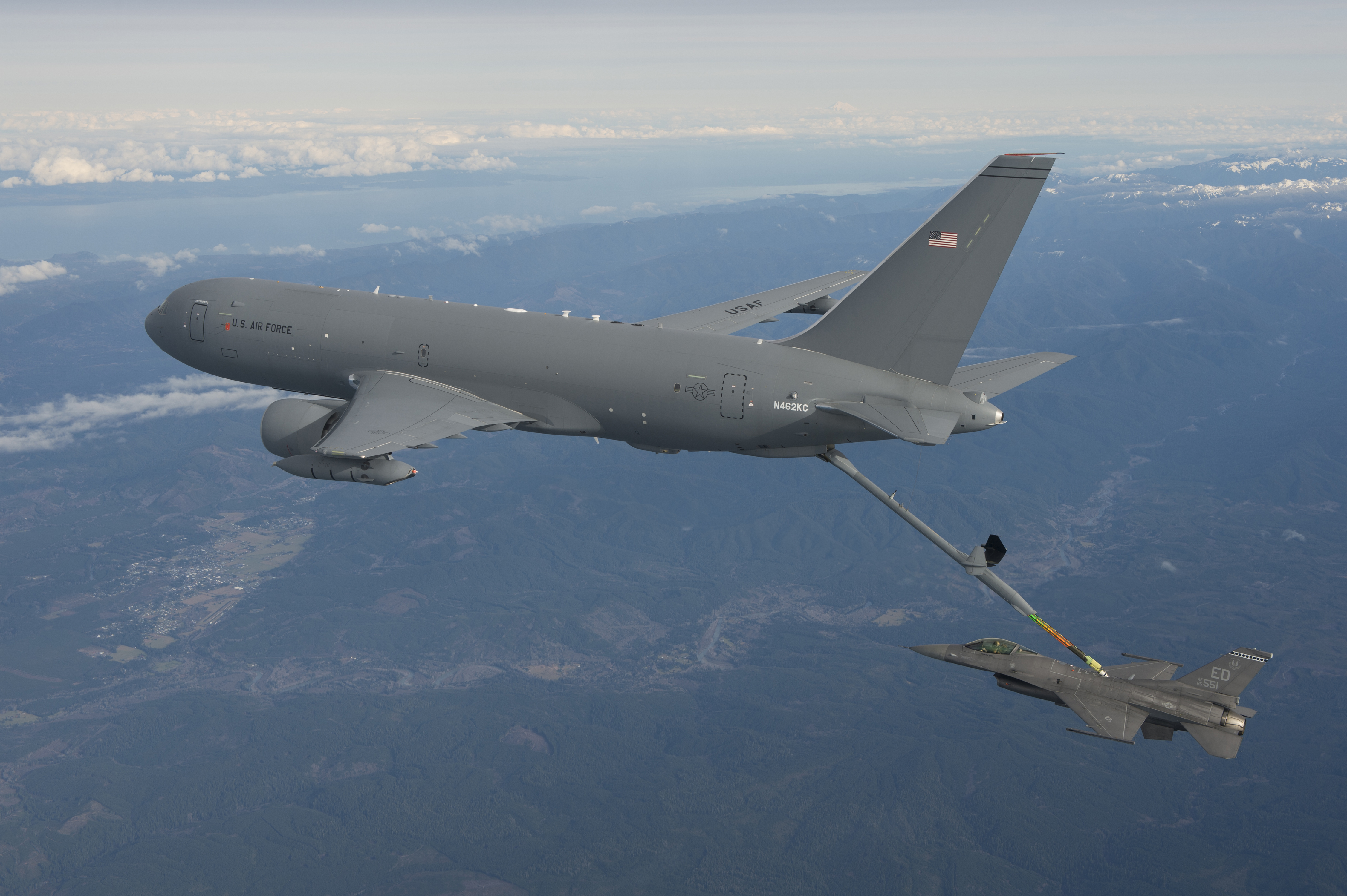 An F-16 flies up on the tanker's rear fuel hose.
