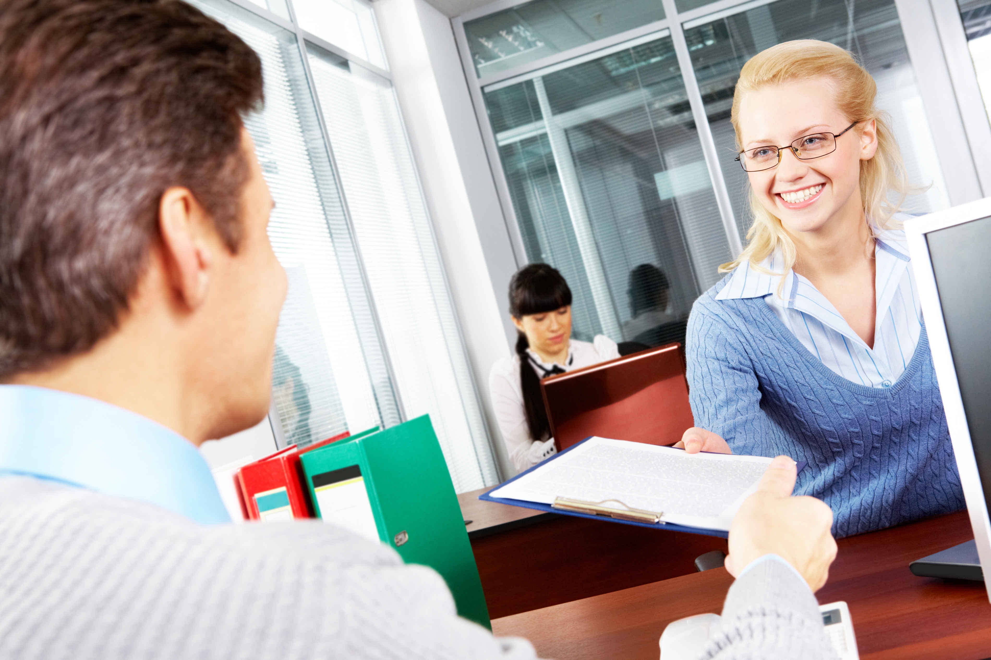 Smiling woman at bank applying for a loan.