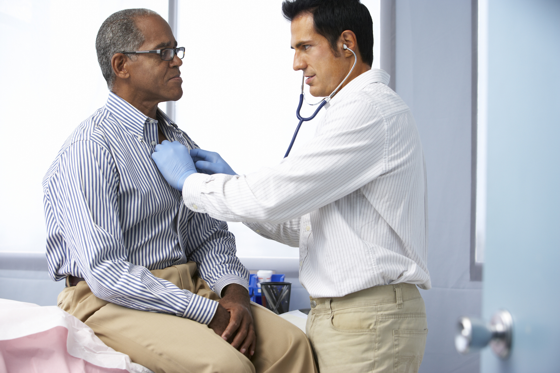 Doctor with stethoscope examining older man