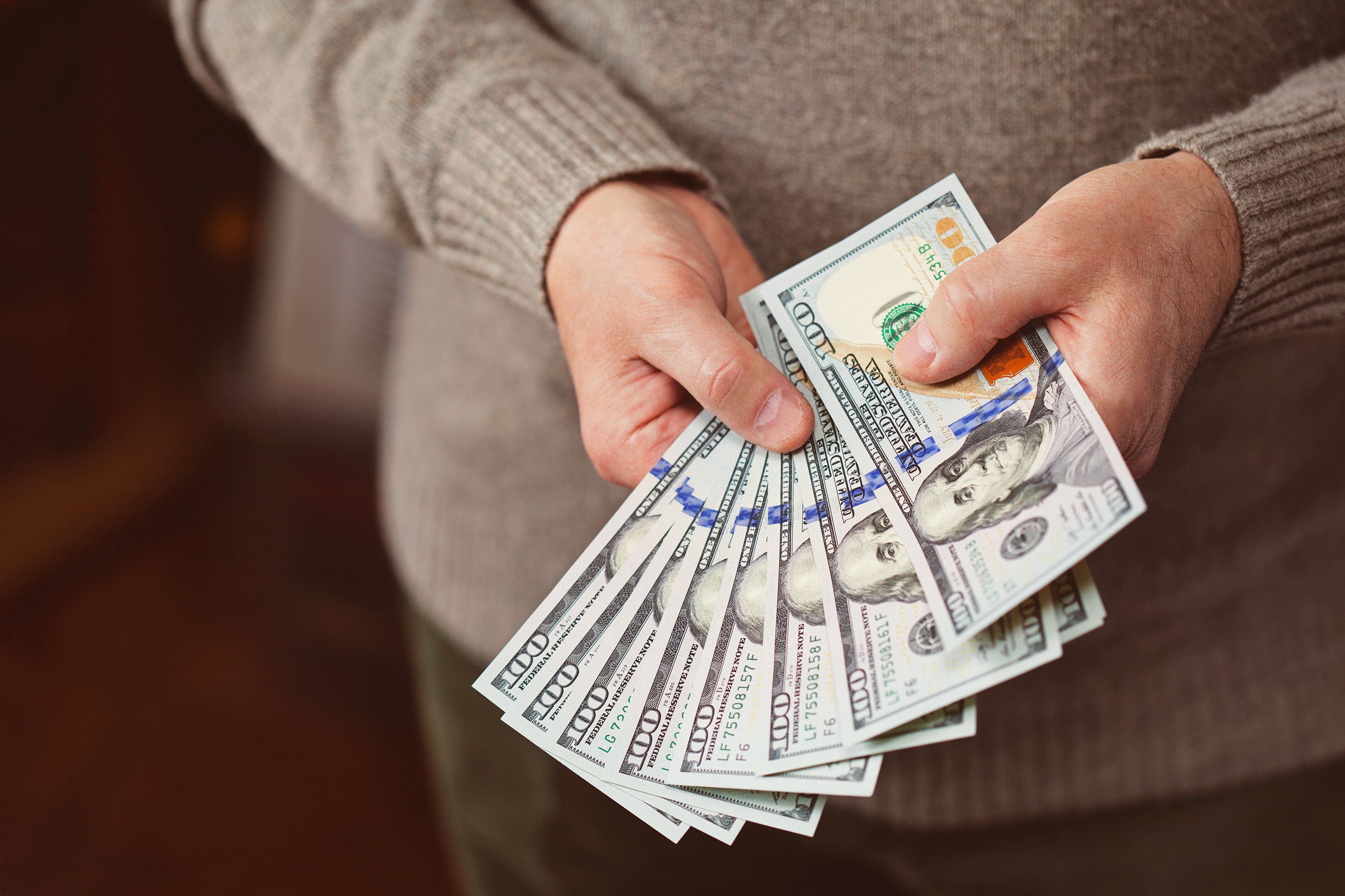 Man holding hundred dollar bills