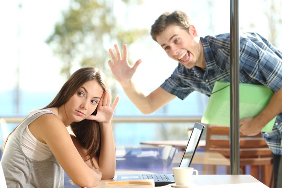 A woman in a coffee shop tries to hide from a blind date.