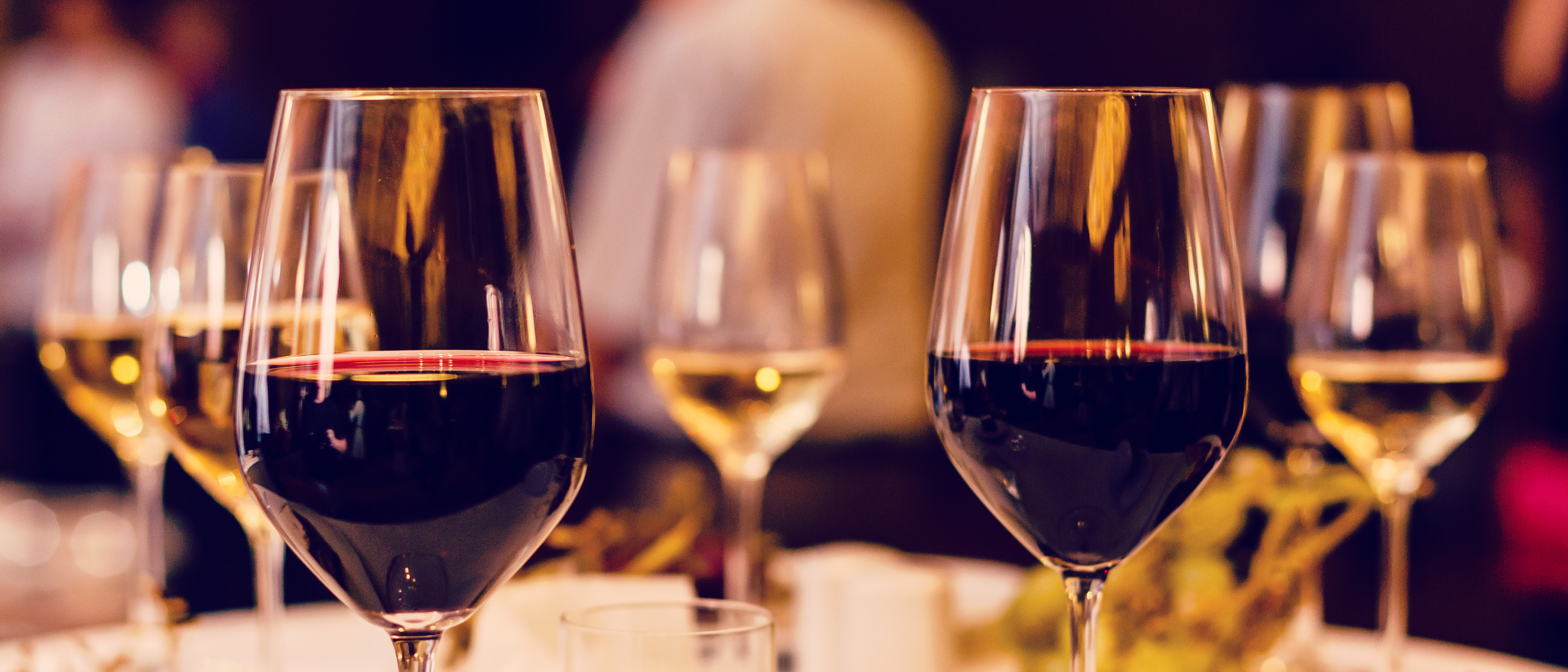 A set of filled wine glasses on a table.