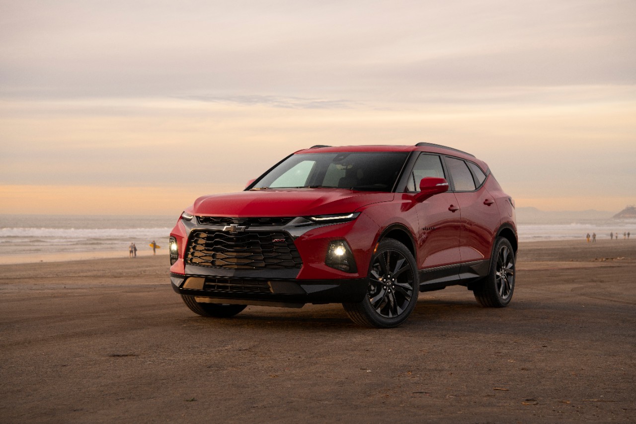 A red Chevy Blazer crossover parked on a beach.