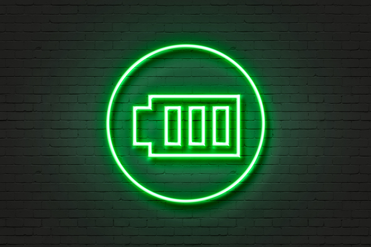 A green neon light in the shape of a battery.