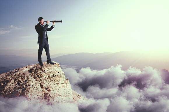A man looking into the distance on a mountain top.