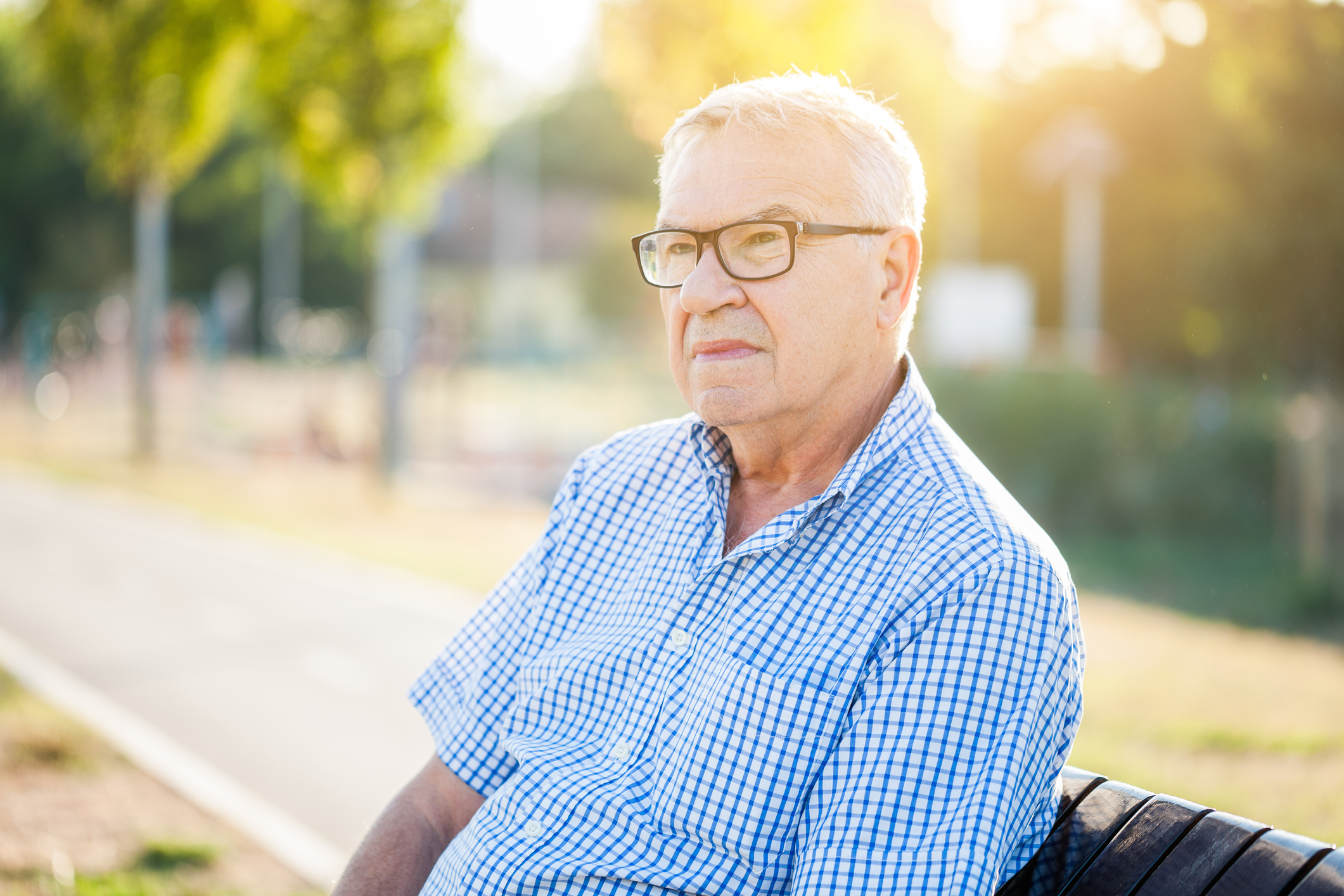 Senior man with serious expression sitting outdoors