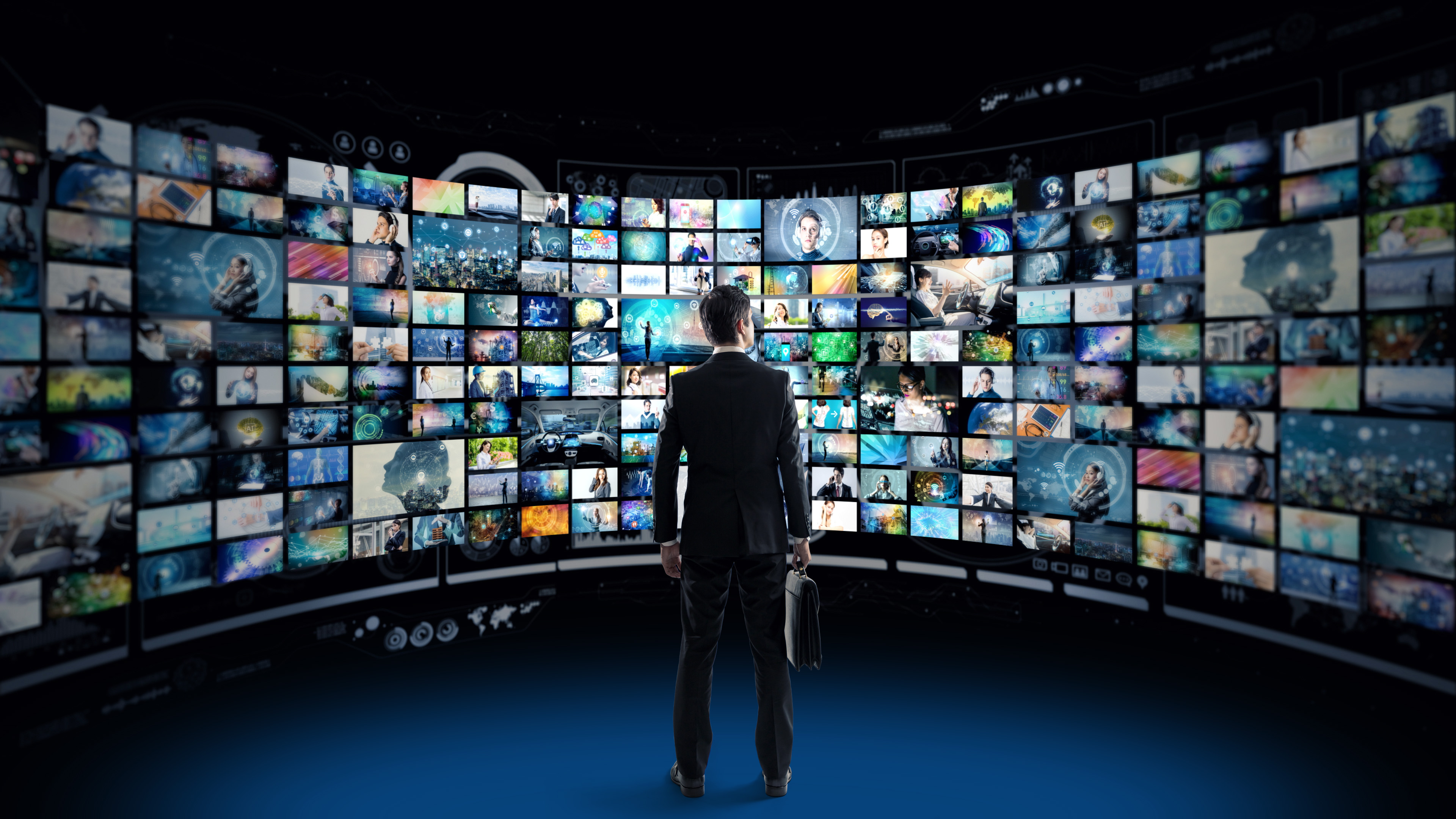 Man standing in front of screen with hundreds of ads being displayed,