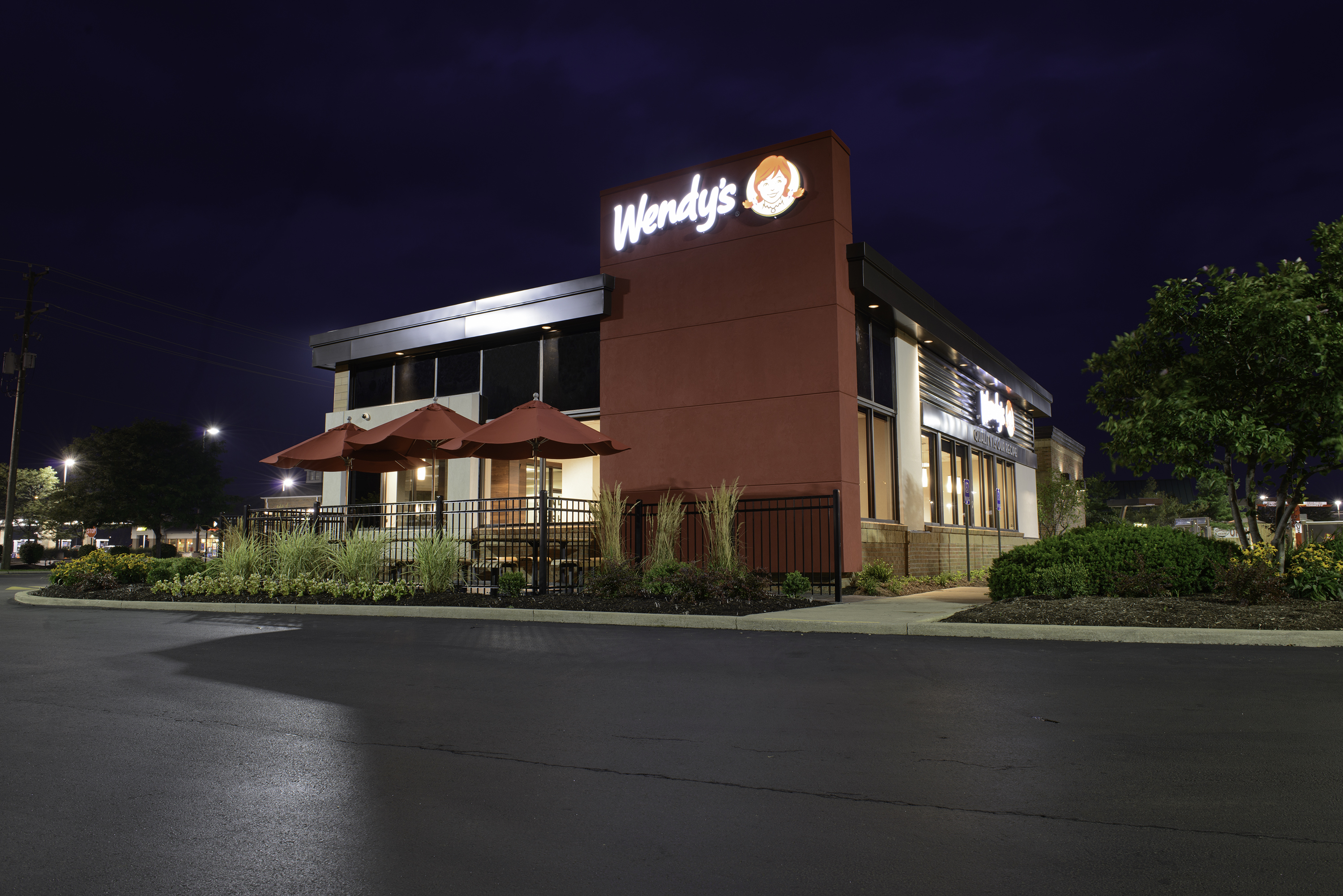 The illuminated exterior of an updated Wendy's restaurant at night.